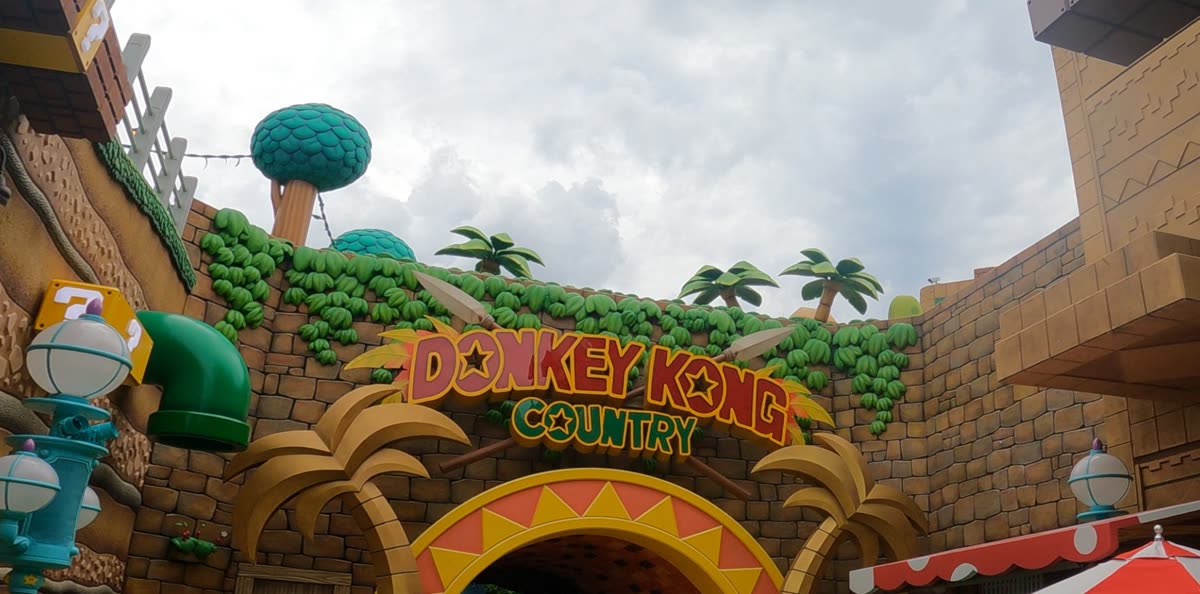 The Donkey Kong Country land entrance with its jungle rockwork, banana vines and giant tiki archway at Epic Universe