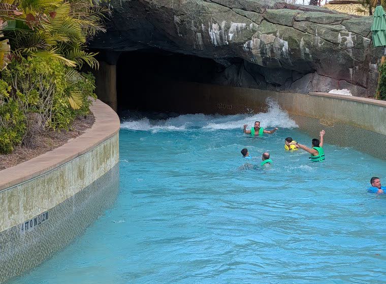 Whitewater rushing into the dark cave section of TeAwa The Fearless River, with guests floating through in life vests