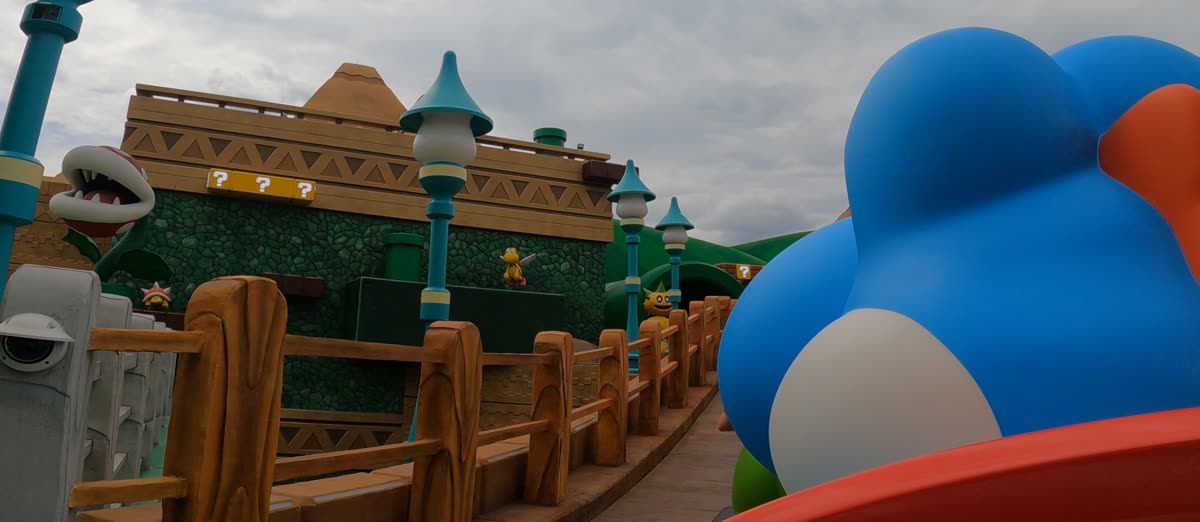 A Yoshi-shaped ride vehicle winding through Mushroom Kingdom scenery on Yoshi's Adventure
