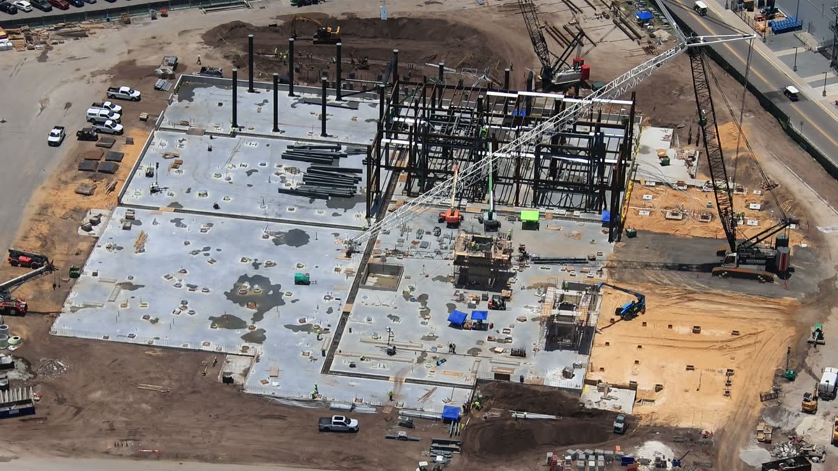 Aerial view of Monstropolis construction at Disney's Hollywood Studios, showing the steel show building frame going up with cranes on site
