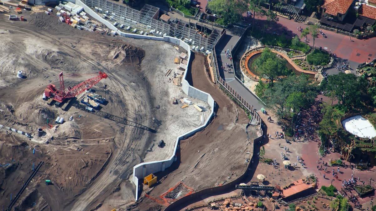 Aerial view of Piston Peak National Park construction in Frontierland at Magic Kingdom, showing concrete retaining walls and a crane on the former Rivers of America footprint